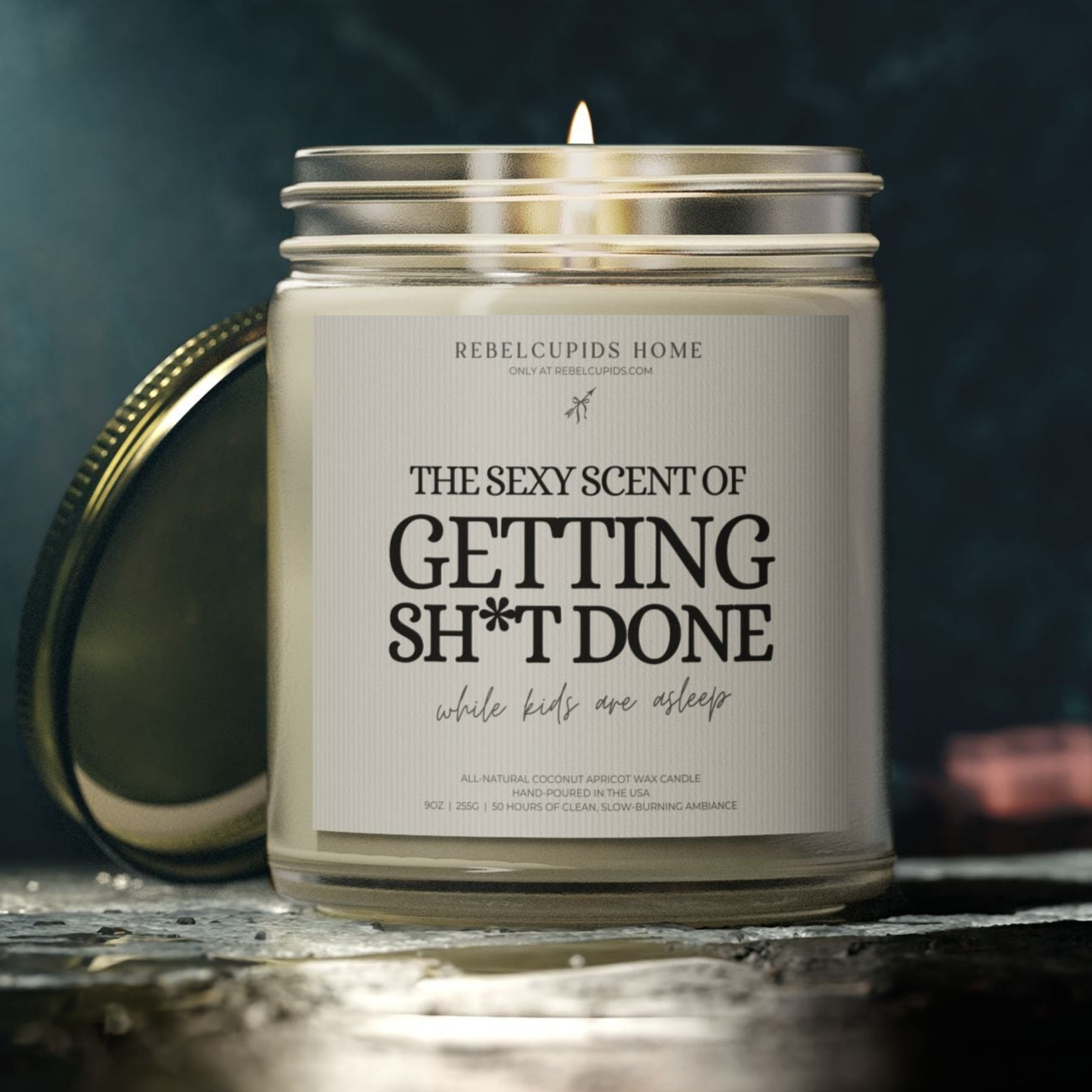 Candle in a glass jar with a humorous label on a dark background
